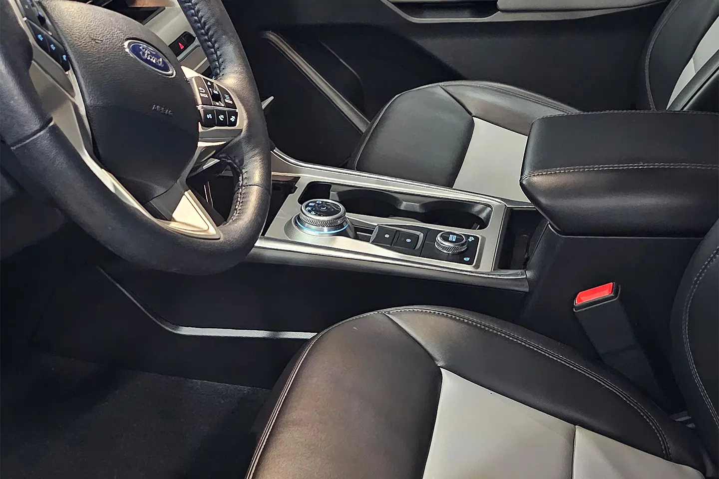 A car 's interior is shown with the steering wheel and center console.