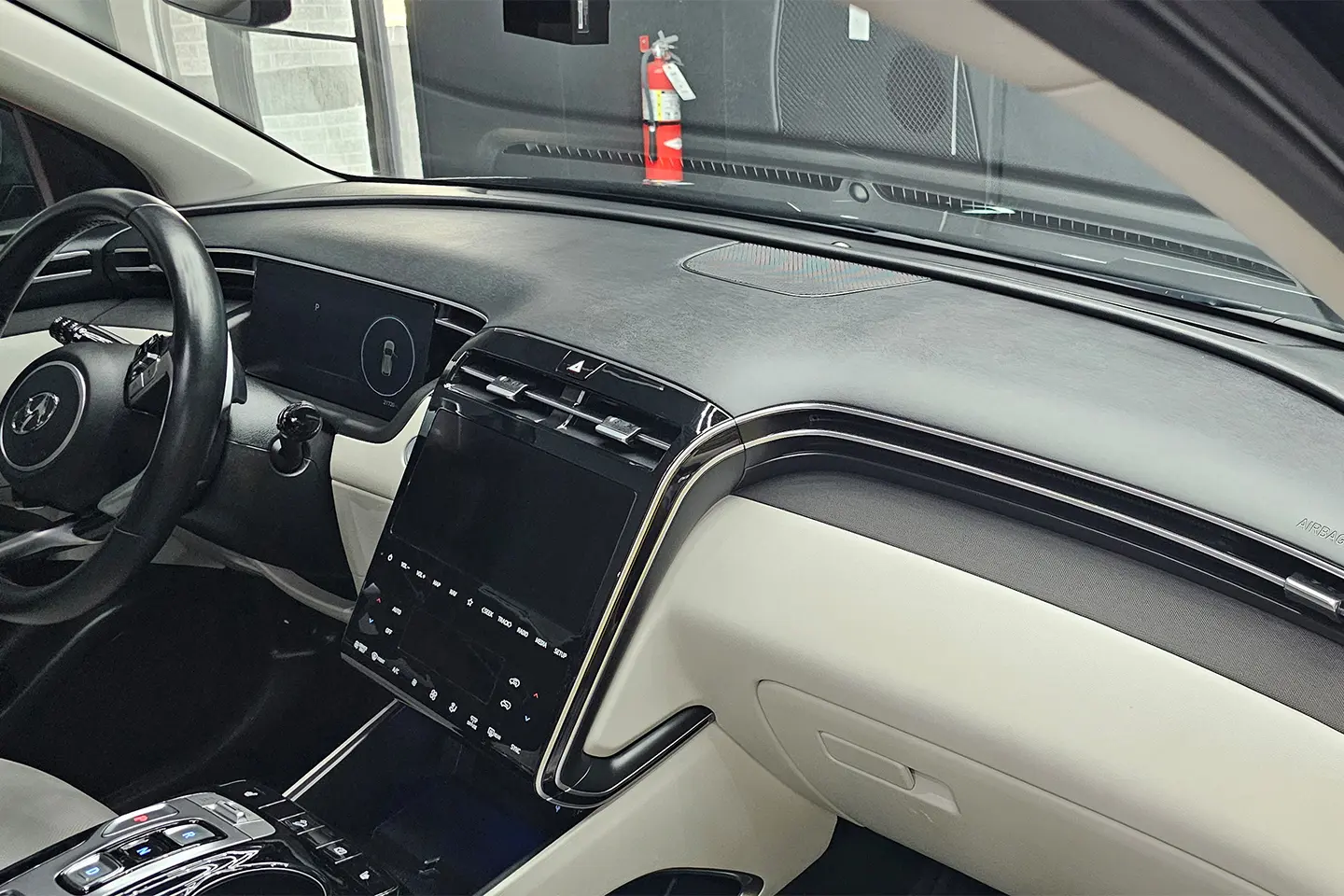 A dashboard of a car with the steering wheel on.
