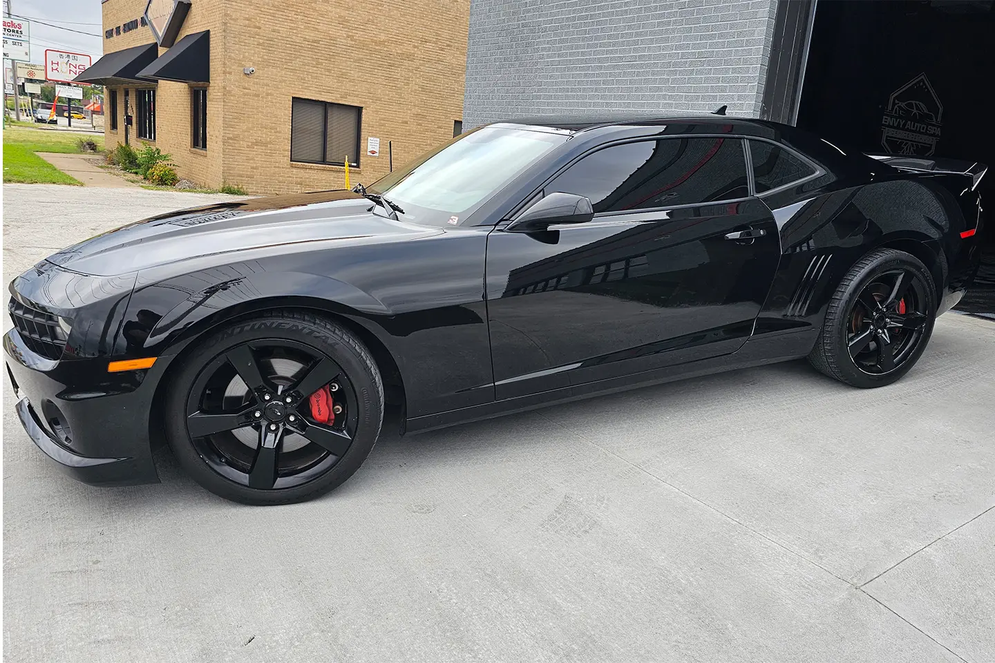 A black sports car parked in front of a building.