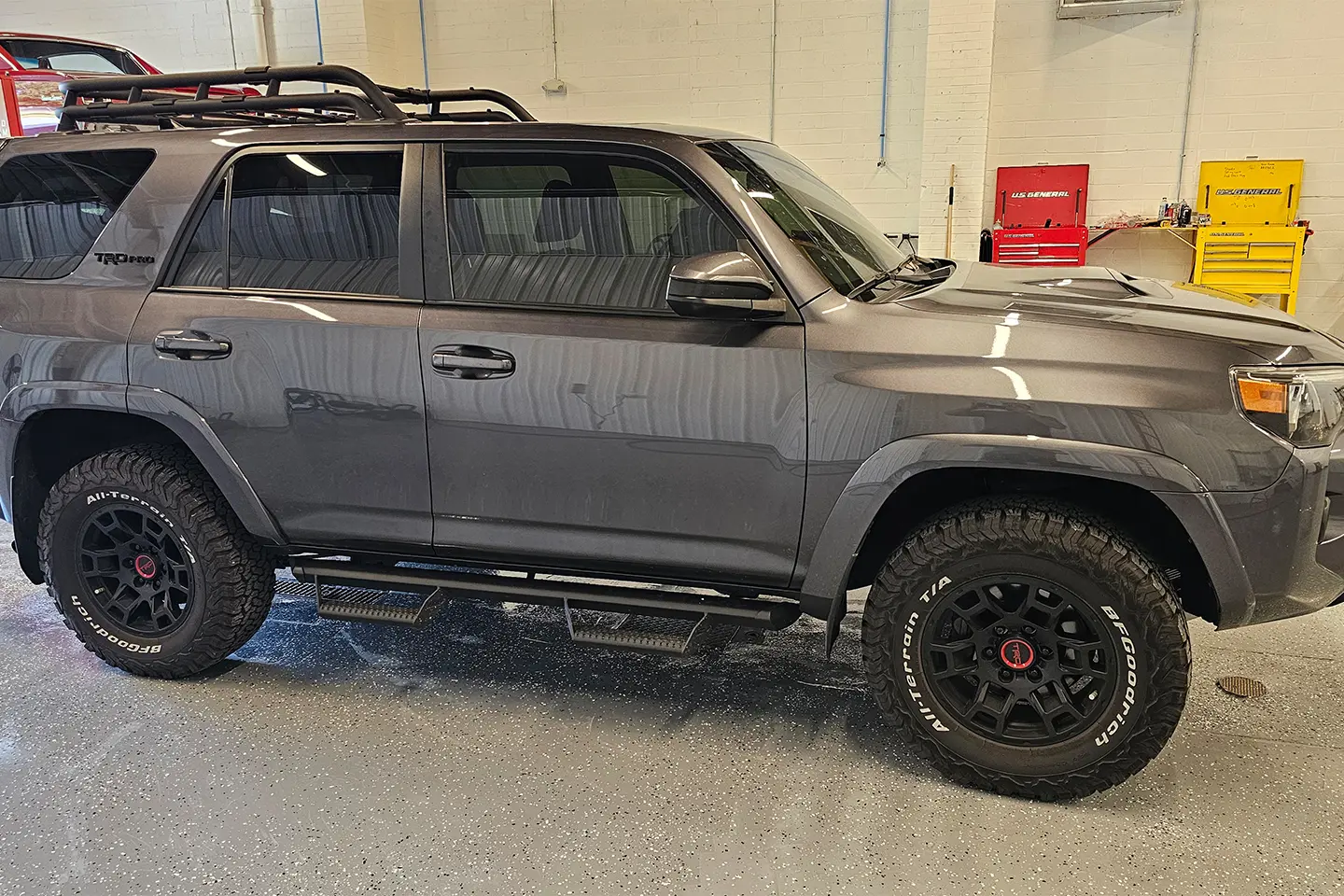 A gray 4 runner with black rims and some tires
