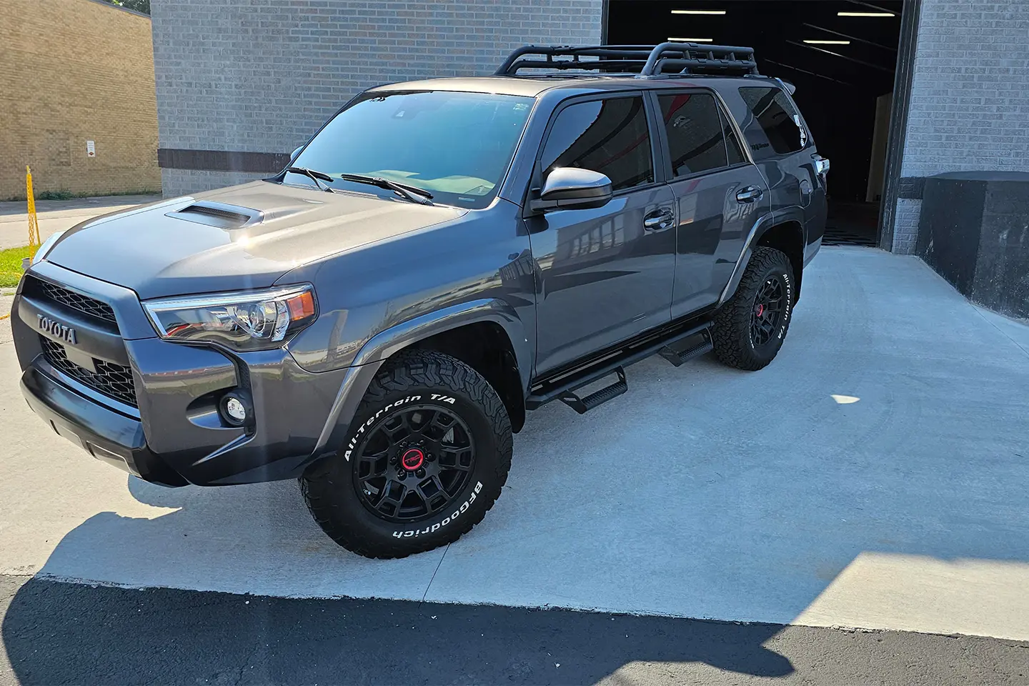 A gray 4 runner parked in the driveway of a garage.