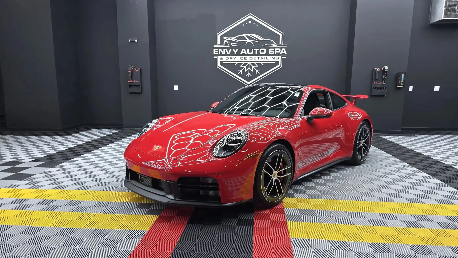 Red sports car in auto detailing shop.